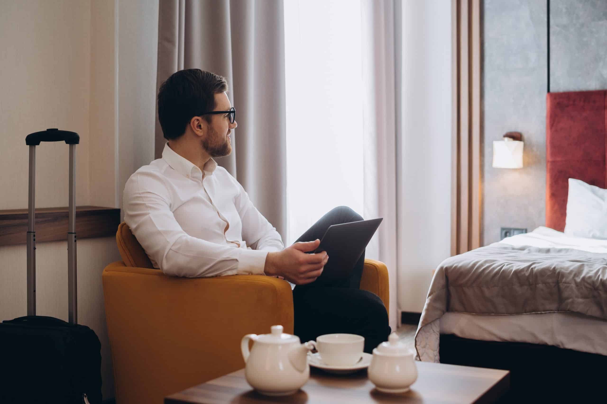 Manager with a laptop in a hotel room during a business trip.